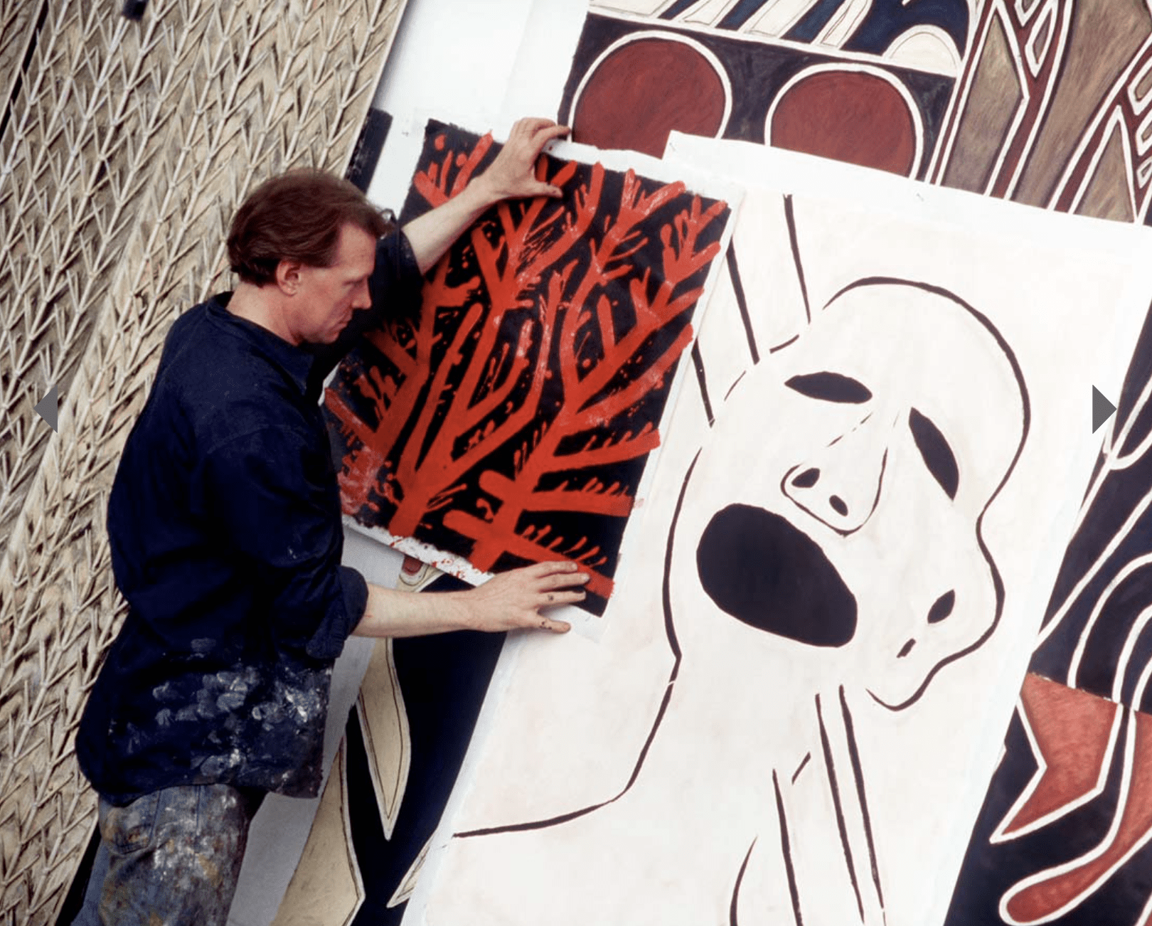 Man holding up black and red painting