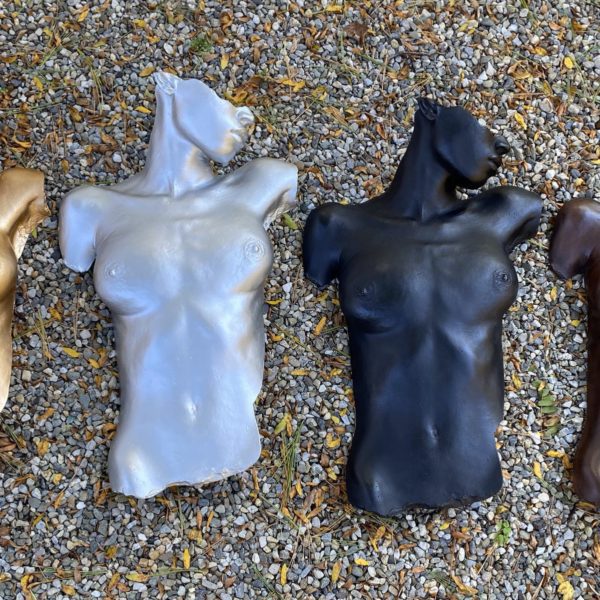 Four female body forms in gold, silver, black, and brown